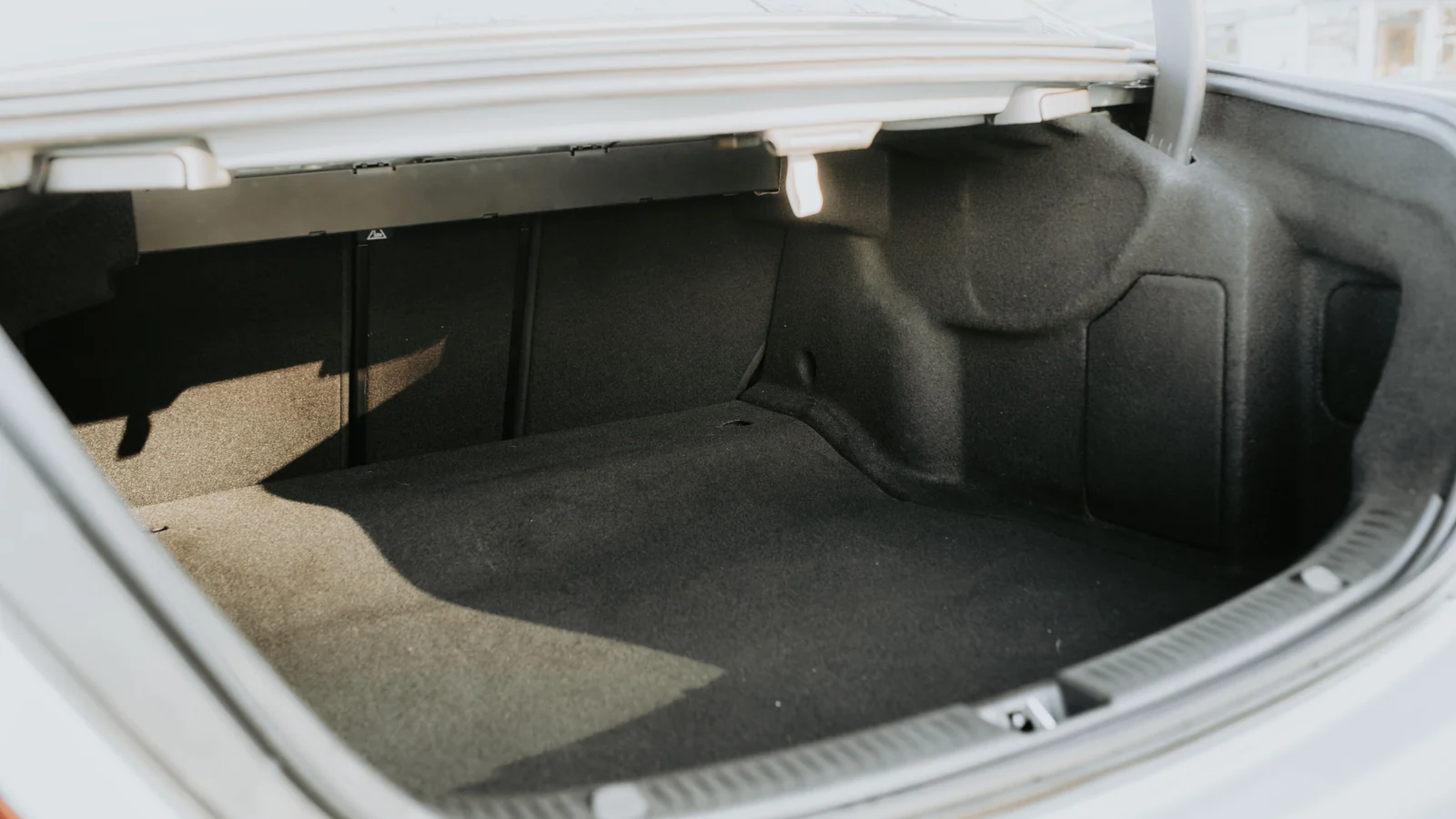 An open, empty car boot with a carpeted luggage compartment.